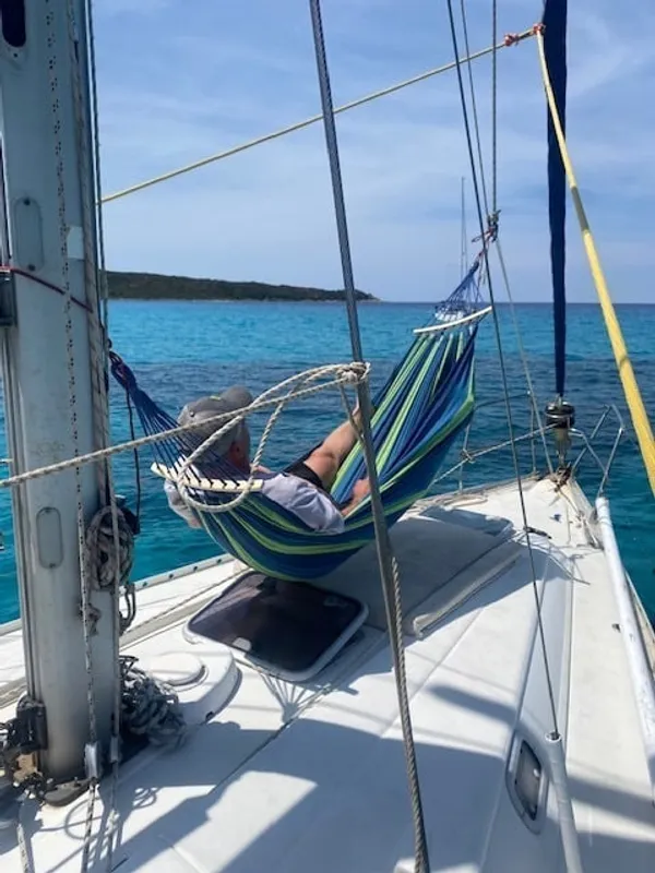 Hamac à l'avant du voilier sur eau turquoise