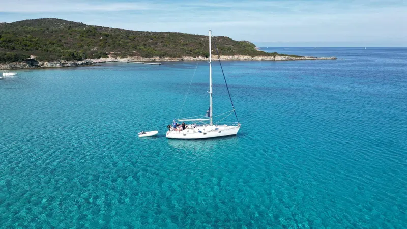 Plage du Lotu avec voilier au mouillage, eau peu profonde idéale familles